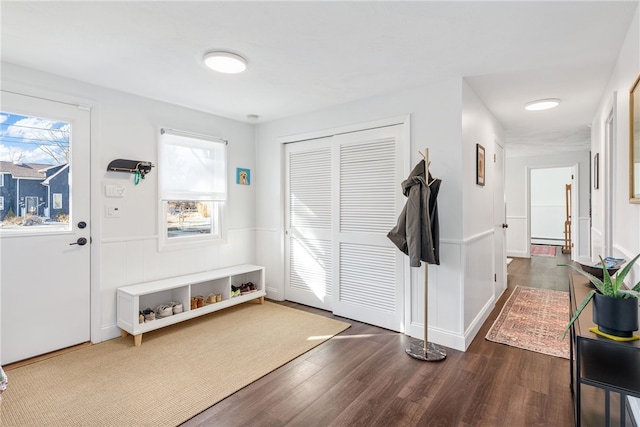 entryway with a wainscoted wall, dark wood finished floors, and a baseboard heating unit