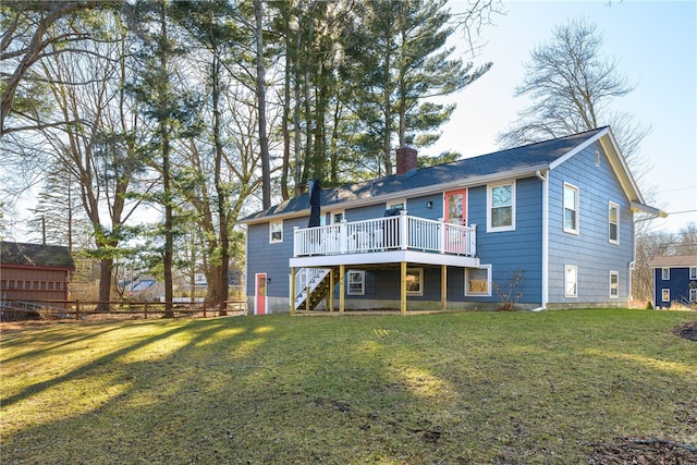 back of house with a lawn, a deck, fence, stairway, and a chimney