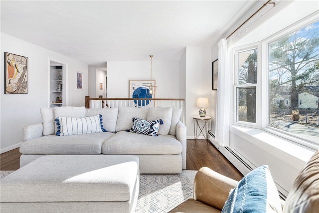 living room featuring baseboards, baseboard heating, and wood finished floors