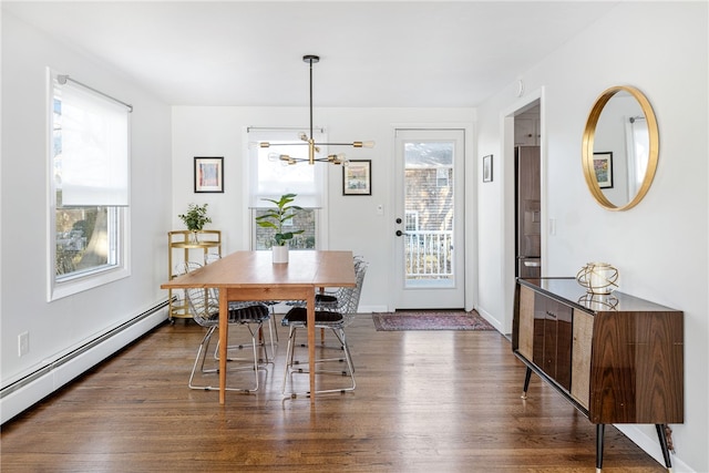 dining room with dark wood finished floors, a notable chandelier, a baseboard heating unit, and baseboards