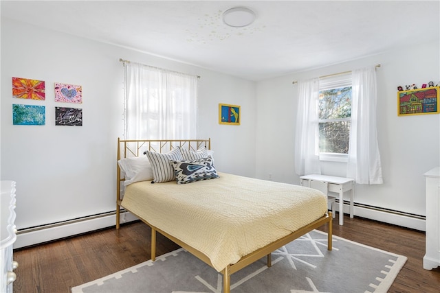 bedroom with baseboard heating and wood finished floors