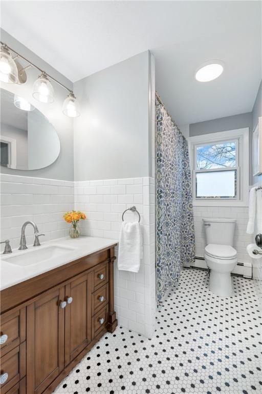 full bath with tile patterned flooring, a baseboard heating unit, tile walls, toilet, and vanity