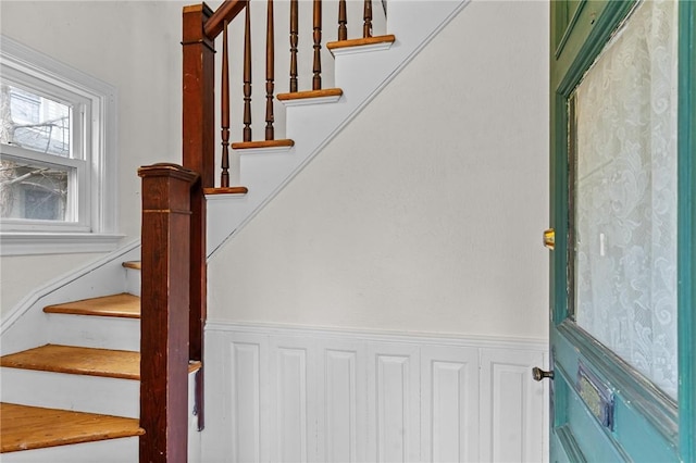 stairway featuring wainscoting