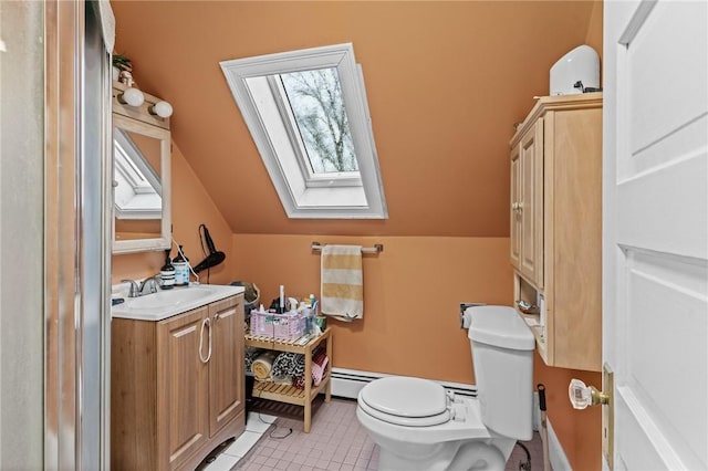 bathroom with toilet, lofted ceiling with skylight, tile patterned floors, and vanity