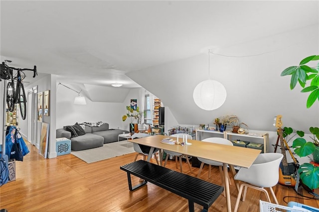 dining area featuring light wood-type flooring and lofted ceiling