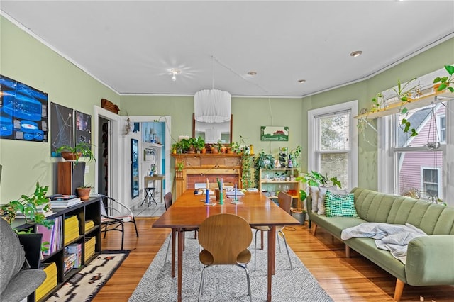 dining area with crown molding and wood finished floors