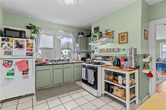 kitchen with under cabinet range hood, white appliances, a healthy amount of sunlight, and green cabinetry