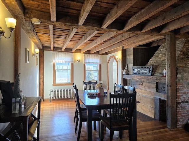 dining room with beam ceiling, wooden ceiling, radiator heating unit, and wood finished floors