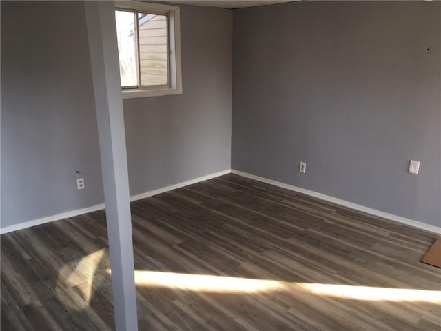 empty room featuring dark wood finished floors and baseboards