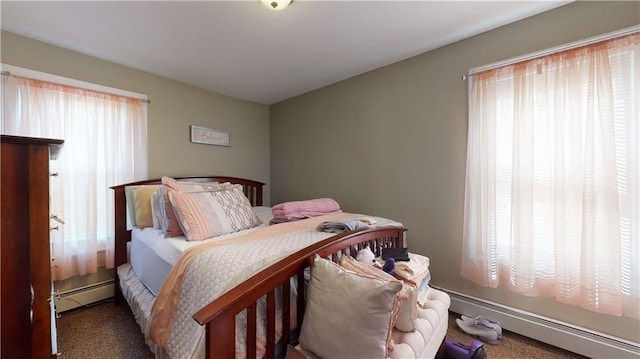 carpeted bedroom with multiple windows and baseboard heating