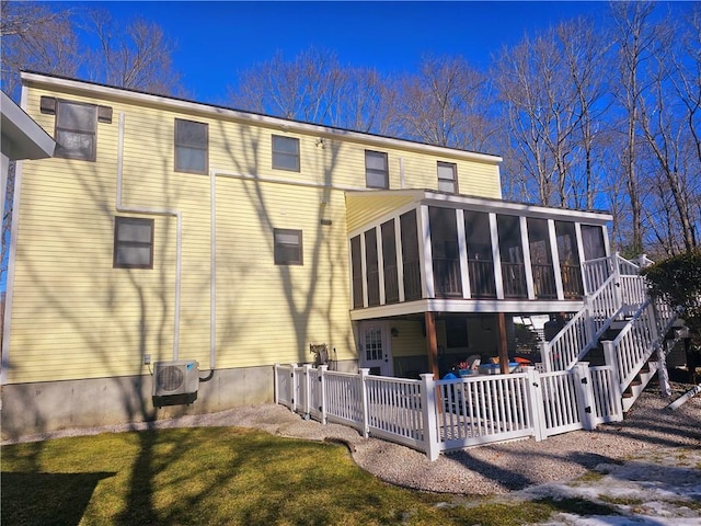 rear view of property with ac unit, a sunroom, a patio area, and a lawn