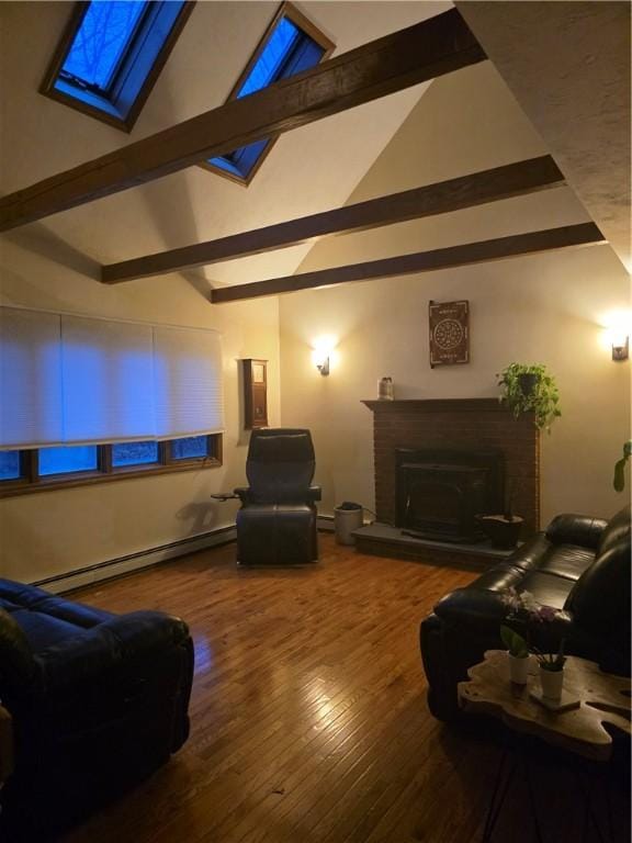 home theater with a fireplace with raised hearth, vaulted ceiling with beams, baseboard heating, and wood finished floors