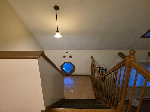 staircase featuring lofted ceiling and tile patterned flooring