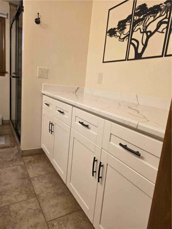 bathroom featuring a stall shower and baseboards