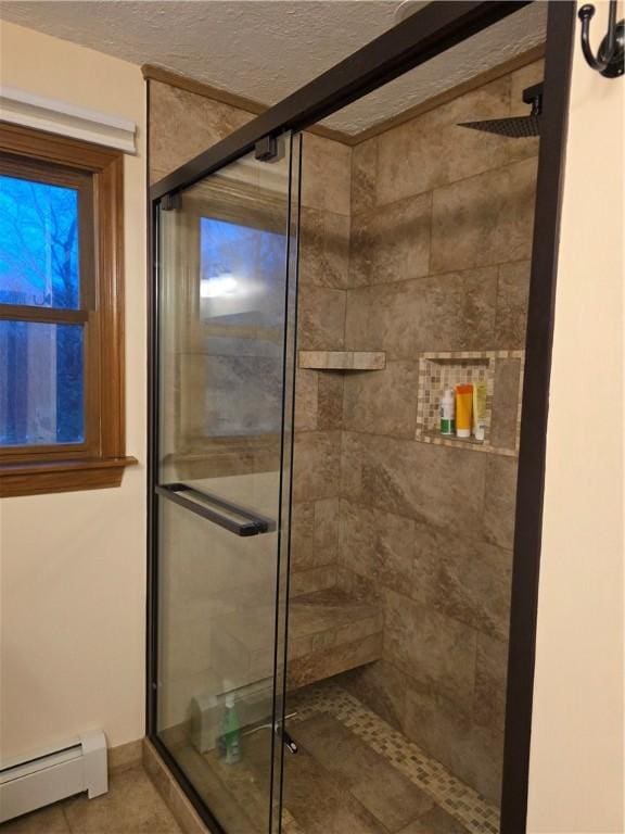 full bath with a baseboard heating unit, a stall shower, and a textured ceiling