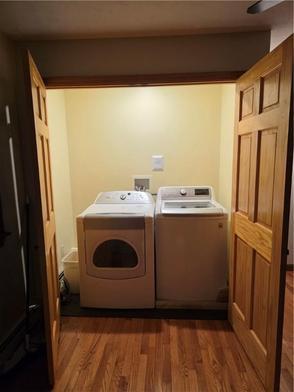 laundry room featuring laundry area, dark wood-type flooring, and washing machine and dryer