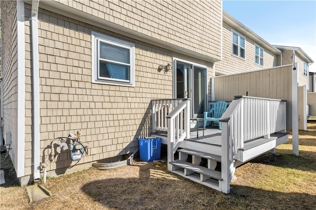 back of property featuring a shingled roof and a wooden deck