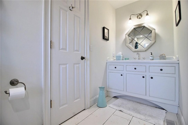 bathroom featuring visible vents, vanity, and baseboards