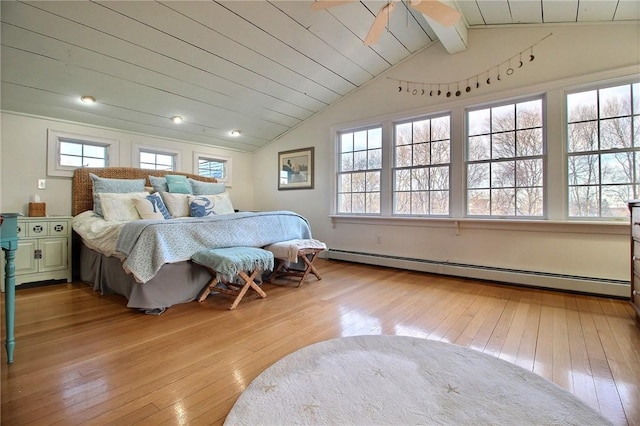 bedroom featuring lofted ceiling with beams, light wood-style floors, multiple windows, and baseboard heating