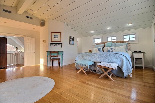 bedroom with vaulted ceiling with beams, hardwood / wood-style floors, and visible vents