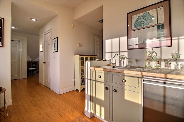 kitchen with light wood finished floors, visible vents, baseboards, tile countertops, and wine cooler