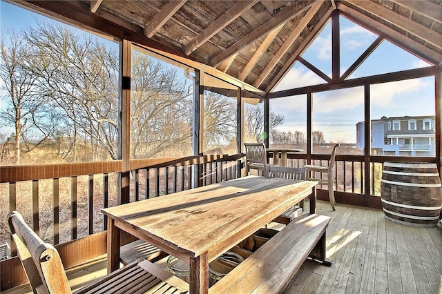 sunroom / solarium featuring vaulted ceiling with beams