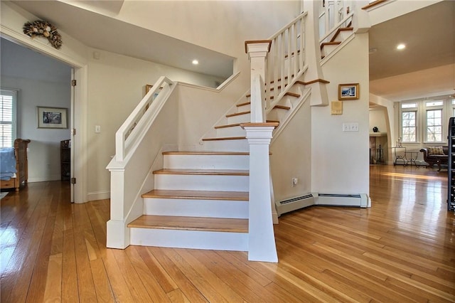 stairway with baseboards, hardwood / wood-style floors, and recessed lighting