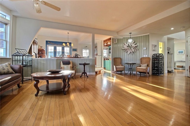 sitting room featuring ceiling fan with notable chandelier and hardwood / wood-style floors