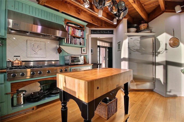 kitchen featuring exhaust hood, beamed ceiling, wood counters, and light wood-style floors