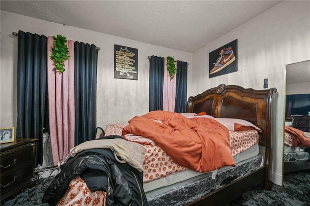 bedroom featuring carpet flooring and a textured ceiling