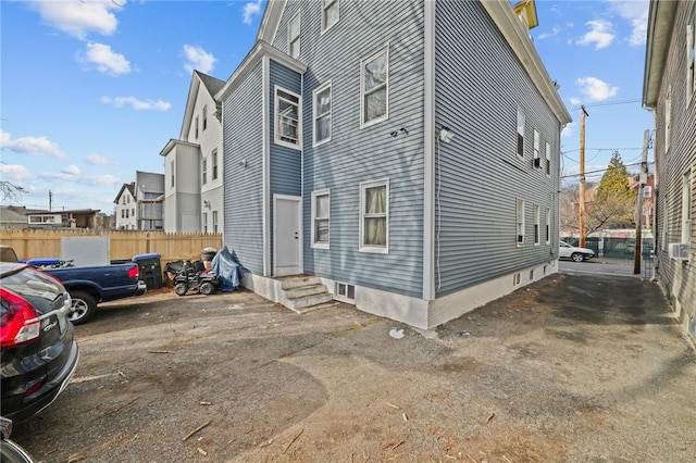 view of property exterior featuring entry steps and fence