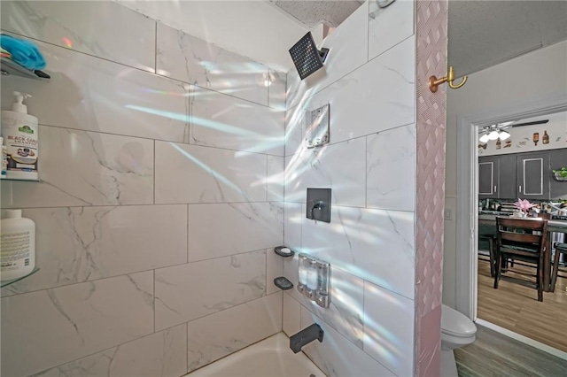 bathroom featuring shower / bathing tub combination, toilet, and wood finished floors