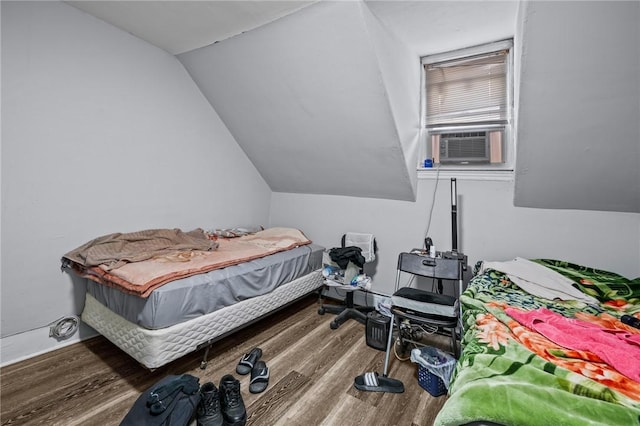 bedroom featuring cooling unit, vaulted ceiling, and wood finished floors