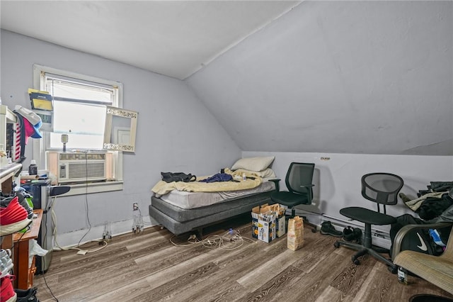 bedroom with vaulted ceiling, cooling unit, and wood finished floors