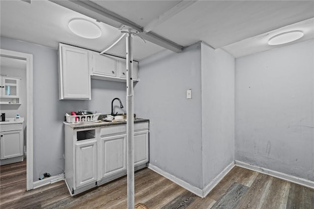 interior space featuring a sink, baseboards, and wood finished floors