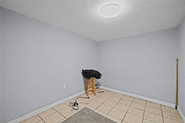 unfurnished room featuring baseboards and light tile patterned floors