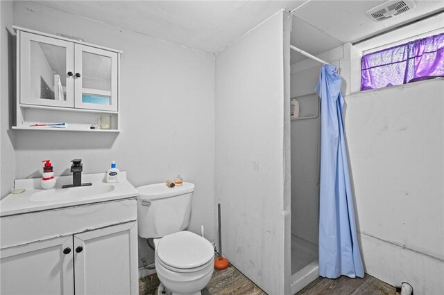 full bath with curtained shower, visible vents, wood finished floors, and vanity