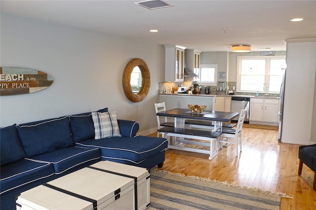 living area featuring recessed lighting, visible vents, and light wood finished floors