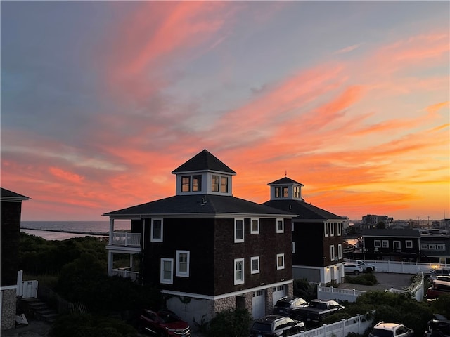 exterior space with a water view, a balcony, and an attached garage