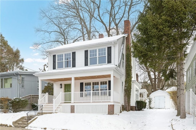 view of front of property featuring a storage shed, a chimney, an outbuilding, covered porch, and stairs