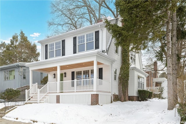 view of front of home with a chimney and a porch