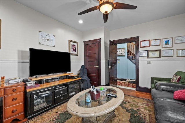 living area with wood finished floors and a ceiling fan