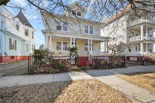 traditional style home featuring a fenced front yard and covered porch