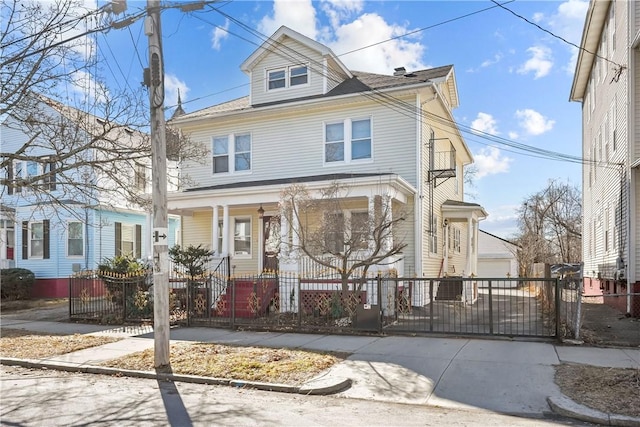 traditional style home with a porch, a gate, and a fenced front yard