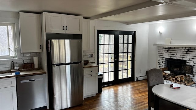 kitchen with decorative backsplash, french doors, appliances with stainless steel finishes, and a baseboard radiator