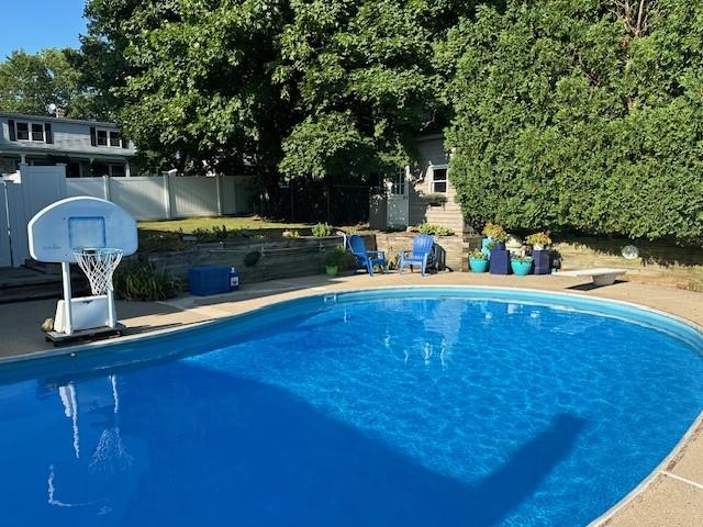 pool with a diving board and fence