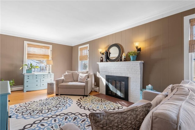 living area featuring a baseboard heating unit, a fireplace, wood finished floors, and crown molding