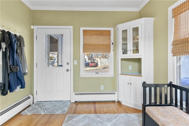 interior space featuring ornamental molding, a baseboard radiator, and wood finished floors