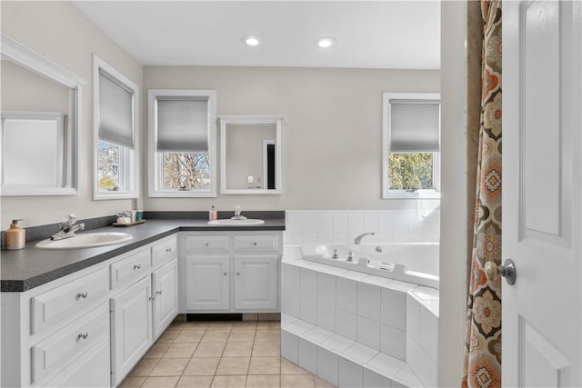 bathroom featuring double vanity, a garden tub, a sink, and tile patterned floors