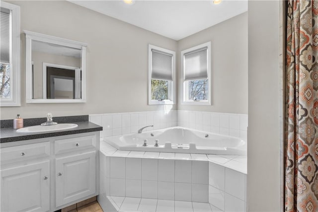 full bath featuring tile patterned flooring, a garden tub, and vanity